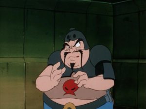 A still from the "Droids" cartoon. The villainous Kybo Ren, a short, rotund man with a mustache and goatee. He looks like he's up to something, despite being locked in a cell. 