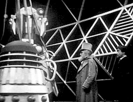 The second Doctor and Maxtible, an older man in Victorian clothing, face off against a Dalek and the Dalek emperor.